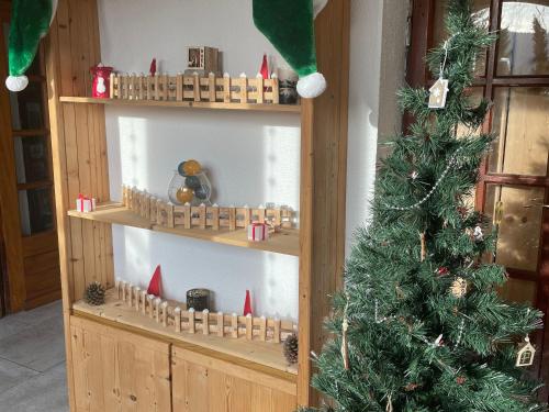 Chambre Noël avec un arbre de Noël et des étagères en bois dans l'établissement Chambres d'hôtes à la montagne, animaux acceptés - FR-1-589-735, à Ventron
