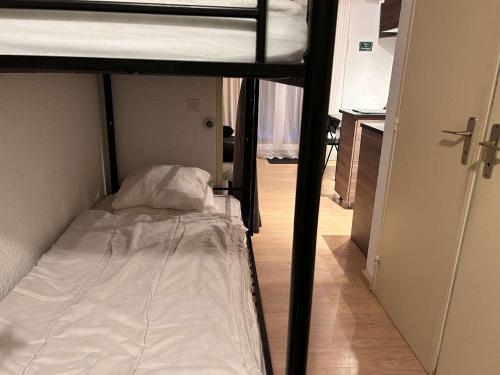 Ce lit superposé se trouve dans une petite chambre dotée d'un couloir. dans l'établissement Studio calme à Risoul, 4 couchages, animaux admis, parking - FR-1-330-586, à Risoul