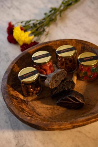 a wooden plate with jars of pickled food and flowers at Reforma Guest House in Mexico City