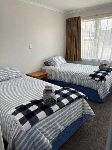 モトゥイーカにあるCentral Motueka Accommodationのベッドルーム1室(毛布付きのベッド2台付)