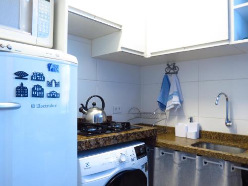 a kitchen with a stove top oven next to a sink at ESPAÇO AZUL Original in Curitiba