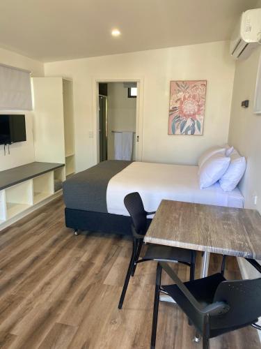 Una habitación de hotel con una cama, una mesa y sillas. en Bacchus Marsh Caravan Park, en Bacchus Marsh