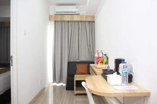 a room with a desk and a room with a couch at Urban Hotel Serpong in Banten