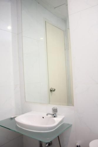 a bathroom with a sink and a mirror at Urban Hotel Serpong in Banten