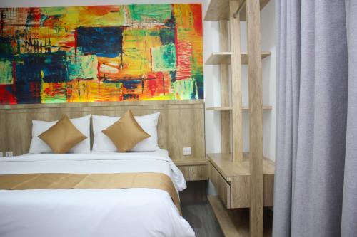 a bedroom with a bed and a painting on the wall at Urban Hotel Serpong in Banten