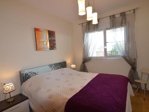 1 dormitorio con cama morada y ventana en Lovely Apartment in Valencia near Sea, en Los Dolses