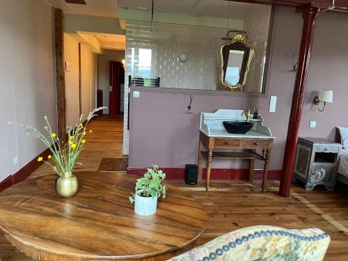 a living room with a table and a sink at Moulin de Maupoy in Saint-Symphorien-de-Marmagne