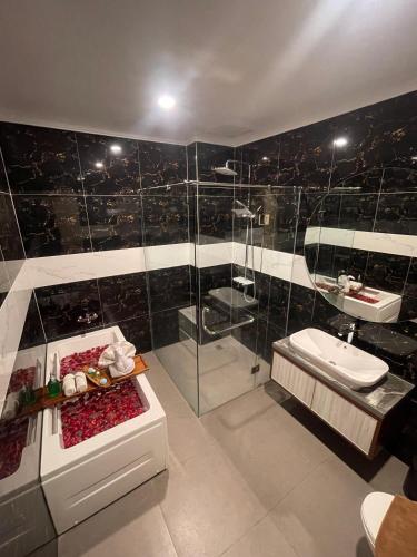 a bathroom with a shower and a toilet and a sink at Solo Grand City in Solo