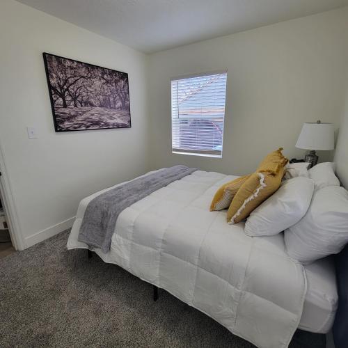 una camera da letto con un letto bianco e una finestra di Cozy Cottage near USU a Logan