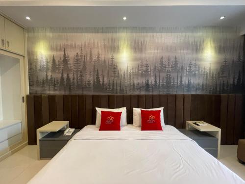 a bedroom with a large bed with two red pillows at Solo Grand City in Solo