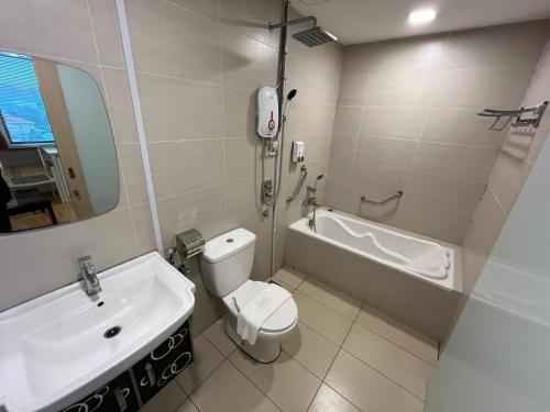 a bathroom with a sink and a toilet and a bath tub at Seeds Hotel Cheras Taman Bukit Segar in Cheras