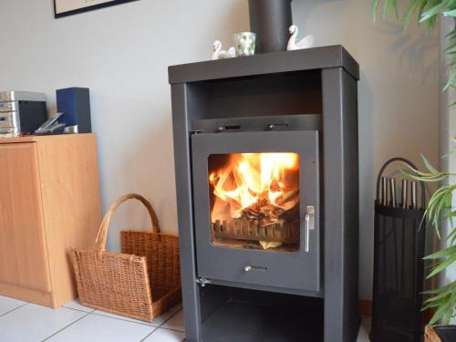 a stove with a fire in it in a room at Apartment with balcony in the Gransdorf Eifel in Gransdorf