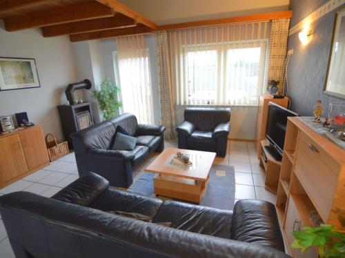 a living room with a couch and chairs and a tv at Apartment with balcony in the Gransdorf Eifel in Gransdorf