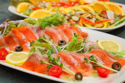 a plate of food with fish and salad on a table at Hotel&Resort Yamanouchi Hills in Yamanouchi