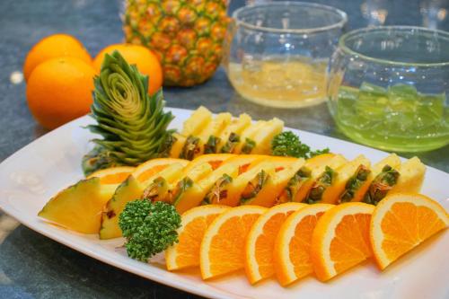 a white plate with oranges and other fruit on a table at Hotel&Resort Yamanouchi Hills in Yamanouchi