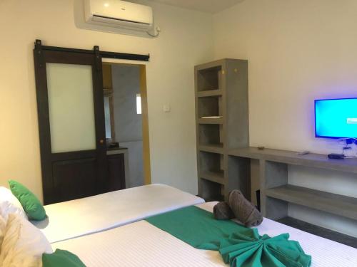 a bedroom with two beds and a tv on a desk at Sithagi Villa Unawatuna in Unawatuna