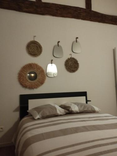 a bedroom with a bed and some mirrors on the wall at jolie maison campagnarde in Gevrolles