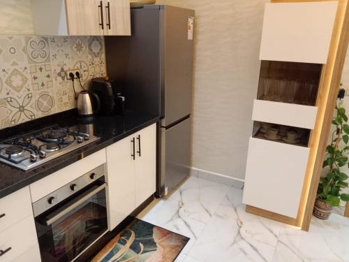 a kitchen with white cabinets and a stove top oven at Azur appartement essaouira in Essaouira