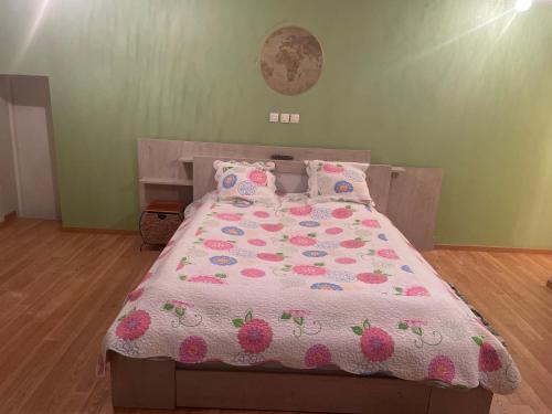 a bedroom with a large bed with a pink comforter at Chambre verte spacieuse côté aéroport in Pusignan