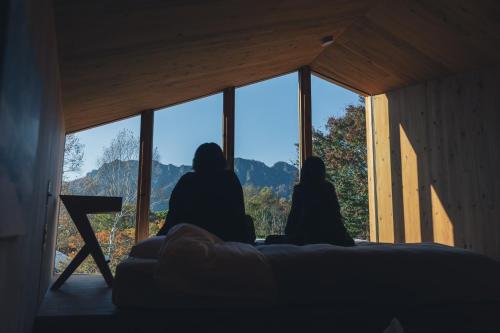 two people sitting on a couch looking out of a window at Earthboat Togakushi in Nagano