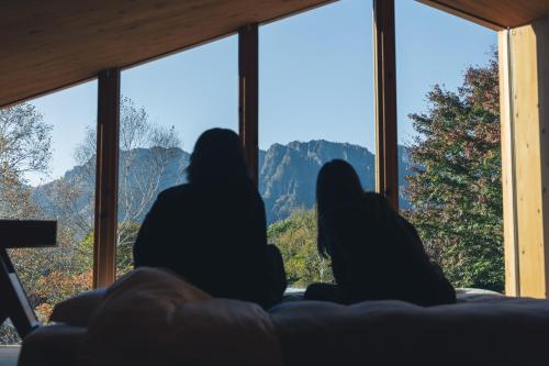 two women sitting on a couch looking out the window at Earthboat Togakushi in Nagano
