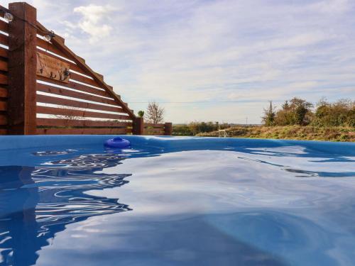 a swimming pool with blue water at Mischief in Harpham