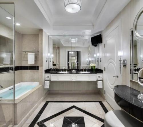 a bathroom with a tub and a large mirror at The Palazzo at The Venetian Resort by Suiteness in Las Vegas
