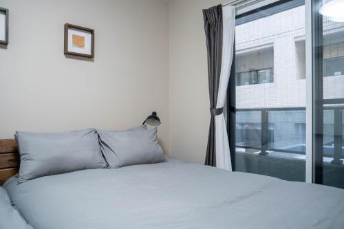 un dormitorio con una cama y una ventana en Zabo Hills 201, en Sapporo