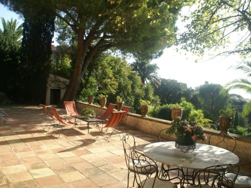 カンヌにある18th century villa in Cannes with poolの木のあるパティオ(椅子、テーブル付)