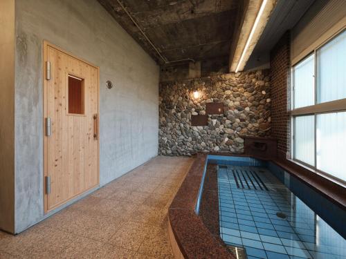 a swimming pool in a room with a door at 三笠館Mikasakan 別館 in Kinokawa