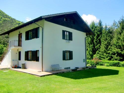 a large white house with a grass yard at Belvilla by OYO Piva Intera in Pieve Di Ledro