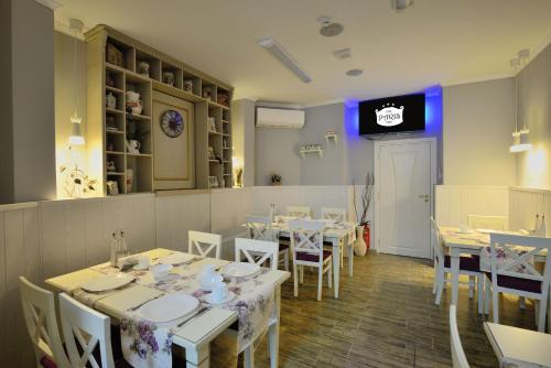 a dining room with tables and chairs and a tv at Villa Paris in Hisarya