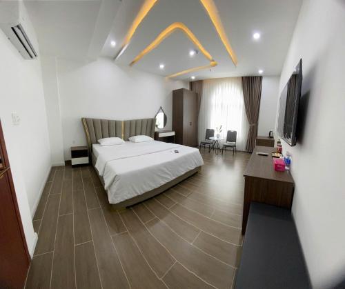 a hotel room with a bed and a television at Times Hotel in Trảng Bàng