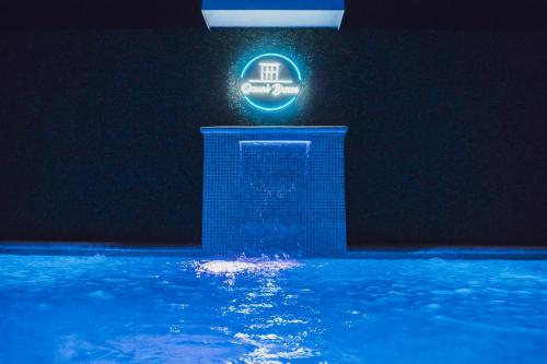 a neon sign in a swimming pool at night at Ocean's Breeze Apartment and Rooms in Puerto Viejo