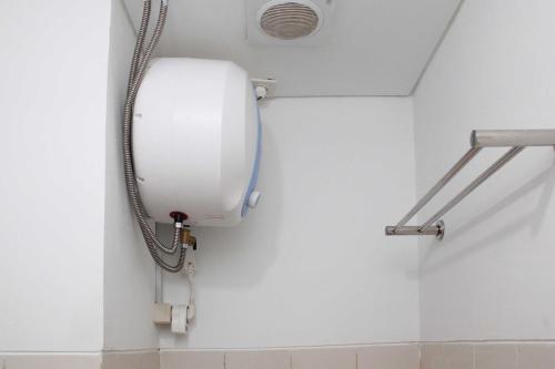 a shower in a bathroom with a soap dispenser at Nice and Elegant Studio at Riverview Jababeka Apartment By Travelio in Cikarang