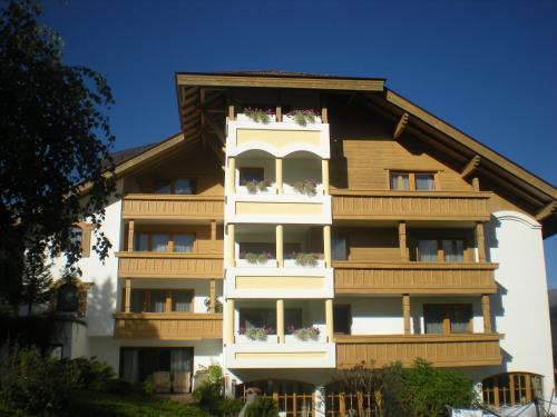 an apartment building with balconies and flowers on it at Hotel White Mountain in Telfes im Stubai