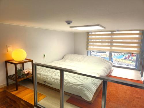 a bedroom with a bed on a balcony with a window at Majestic Seoul Stay Central in Seoul