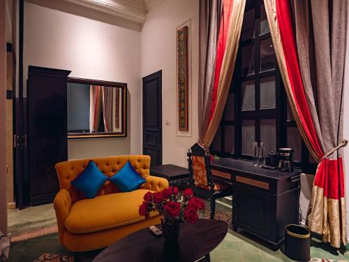 a living room with a yellow couch and a table at House of Tugu, Old Town Jakarta in Jakarta