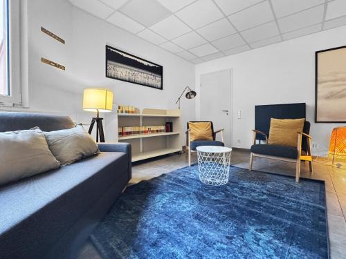 a living room with a couch and a blue rug at Gruppenfreundl Komfort Apt für 18 im Zentrum Stuttgarts in Stuttgart