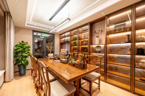a dining room with a wooden table and chairs at Fuxue QiuGuo Hotel Beijing Nanluoguxiang Siheyuan Branch in Beijing