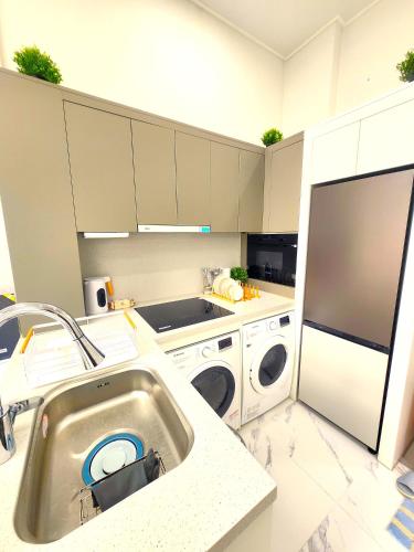 a kitchen with a sink and a washing machine at Majestic Seoul Stay Central in Seoul