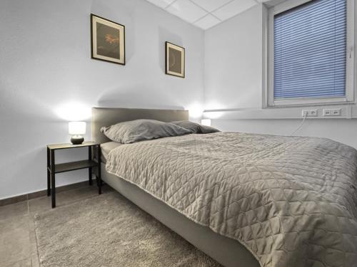 a bedroom with a bed and a nightstand and a window at Gruppenfreundl Komfort Apt für 18 im Zentrum Stuttgarts in Stuttgart