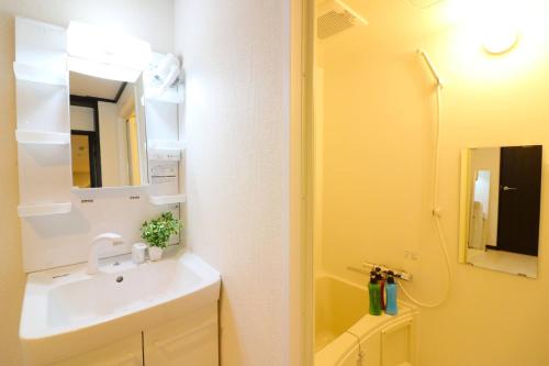 a bathroom with a sink and a toilet and a mirror at Shin Osaka Grand Heights SG21 in Osaka