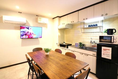 a kitchen with a wooden table with chairs and a microwave at Shin Osaka Grand Heights SG21 in Osaka