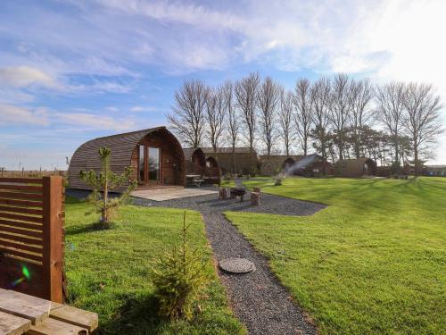 a small building in a grassy field with a garden at Bevy in Harpham
