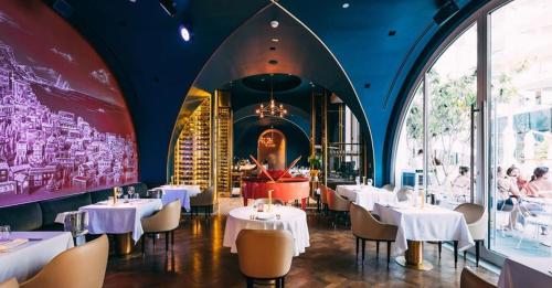 a restaurant with white tables and chairs and a large window at FIVE Palm Residence - Elegant Homes in Dubai
