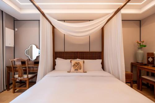 a bedroom with a canopy bed and a desk at Fuxue QiuGuo Hotel Beijing Nanluoguxiang Siheyuan Branch in Beijing