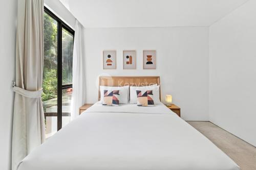 ein weißes Schlafzimmer mit einem großen Bett und einem Fenster in der Unterkunft Sukha by Kozystay - Dago in Bandung