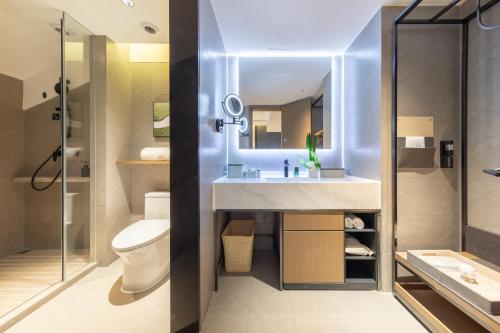 a bathroom with a sink and a toilet and a shower at Atour Hotel Chengdu Sichuan Normal University in Chengdu