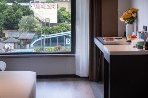 a room with a window with a view of a building at Atour Hotel Chengdu Sichuan Normal University in Chengdu
